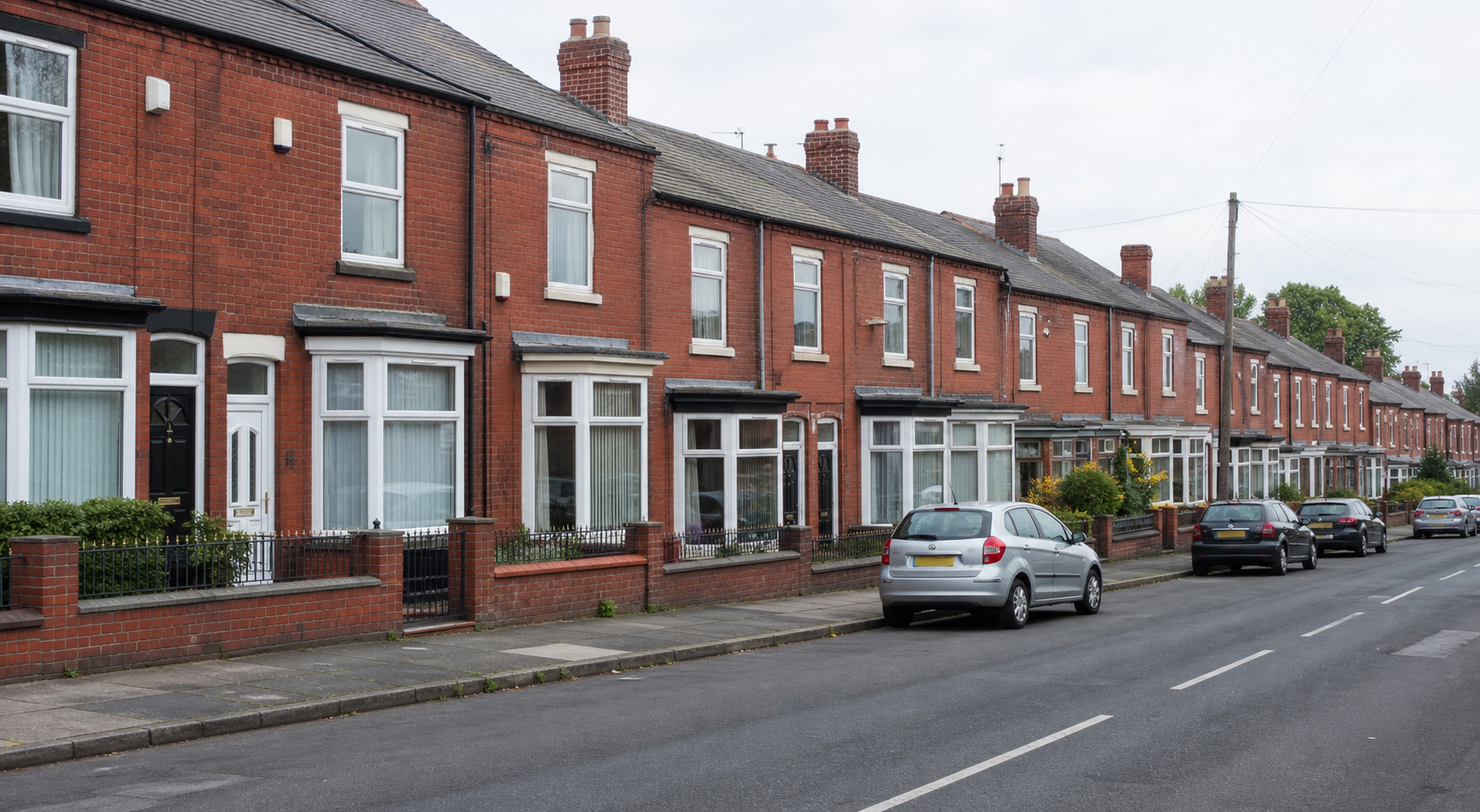 A row of standard red-brick UK terraced houses